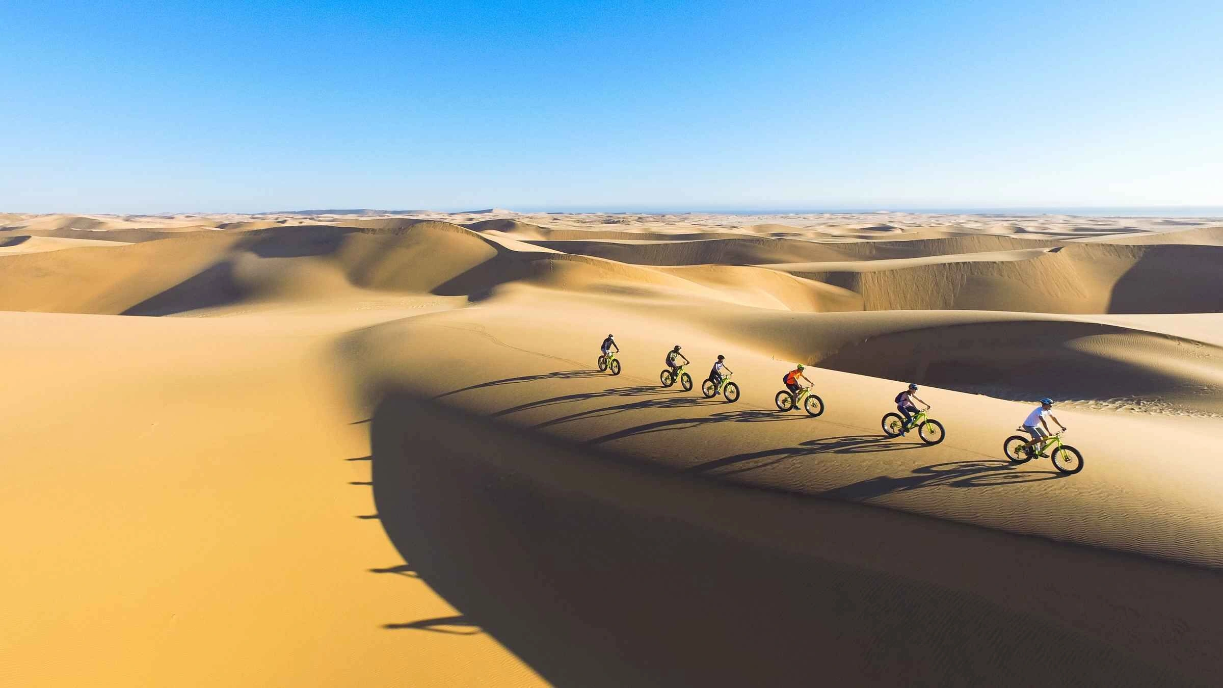 Guests on an e-bike tour past colonial buildings in Swakopmund, Namibia