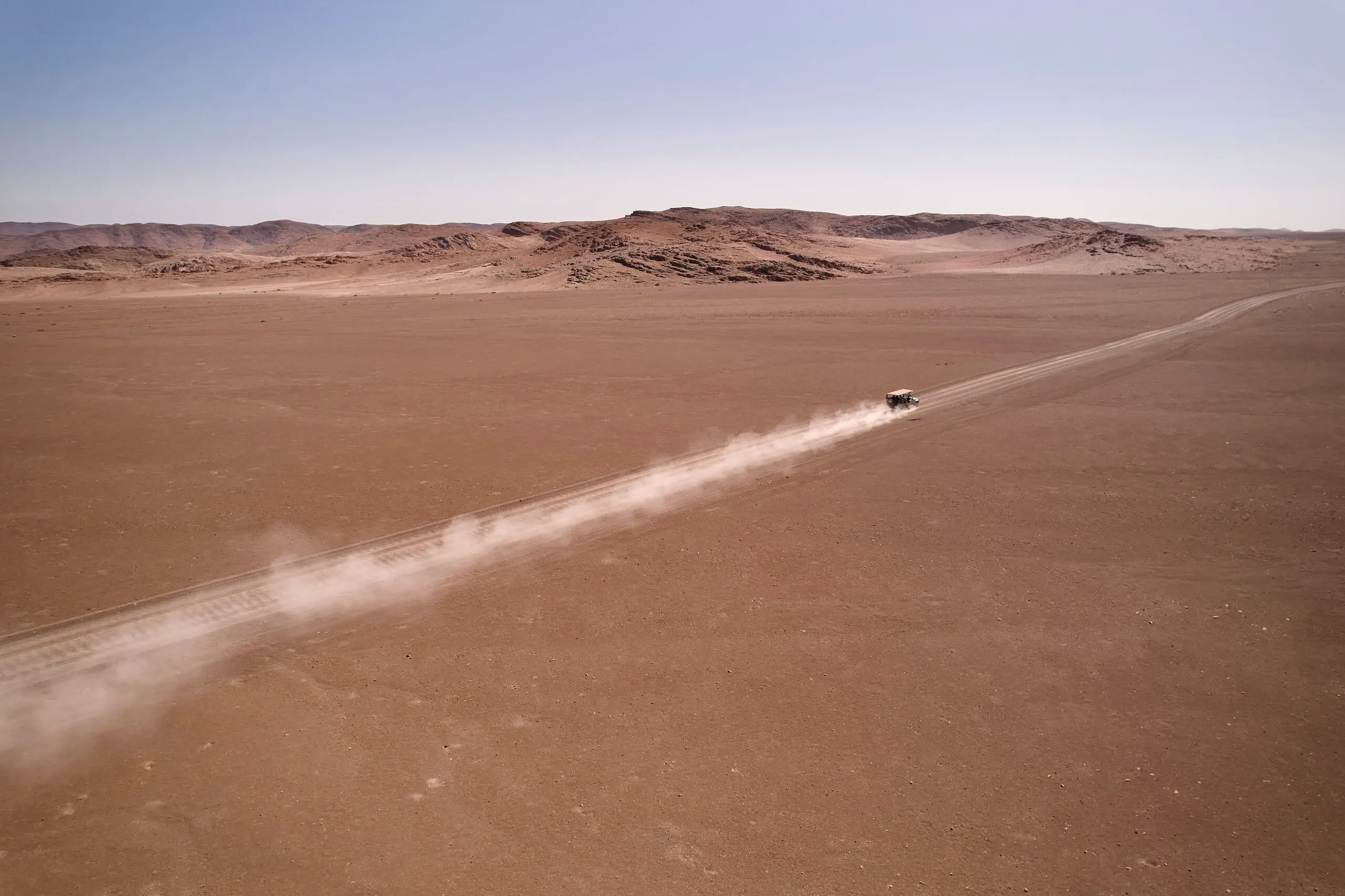 Safari vehicle on a dry riverbed game drive in the Purros Conservancy, Namibia